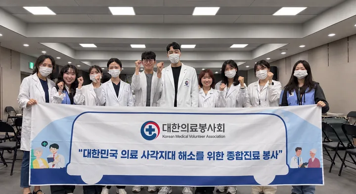 대한의료봉사회 단원들이 현수막을 들고 응원하는 단체 사진